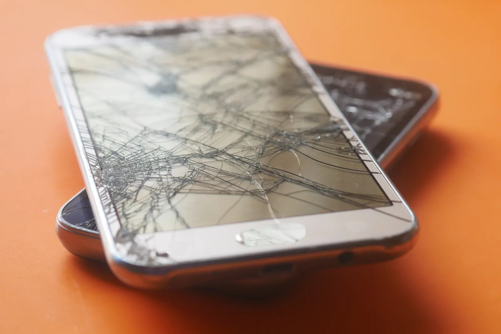 Cracked smartphone screens waiting for screen replacement at UTTECH phone repair in West Valley City, Utah
